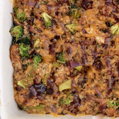 A cheesy low carb casserole made with cauliflower rice, broccoli, bbq chicken and cheese. The BBQ sauce is drizzled on top and the cheesy is melted and golden