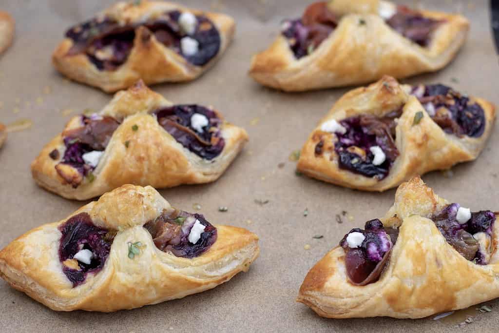 Golden and flaky easy puff pastry appetizers are filled with a sweet and savory blueberry filling, prosciutto and goat cheese. They’re drizzled with honey thyme. Perfect for parties, brunch or quick snacks!