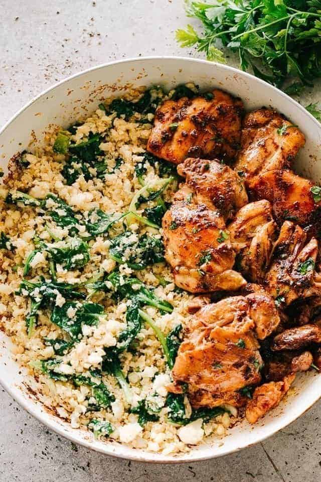 Garlic butter cauliflower rice with spinach and served with chicken for an easy Low Carb side dish
