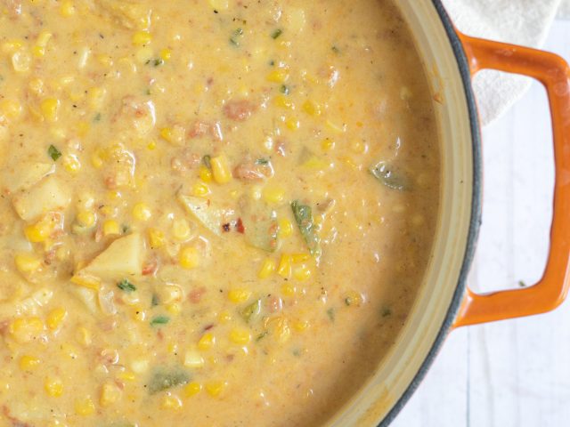 a large dutch oven pan filled with homemade corn chowder. It’s made with chorizo, yellow potatoes and summer squash.