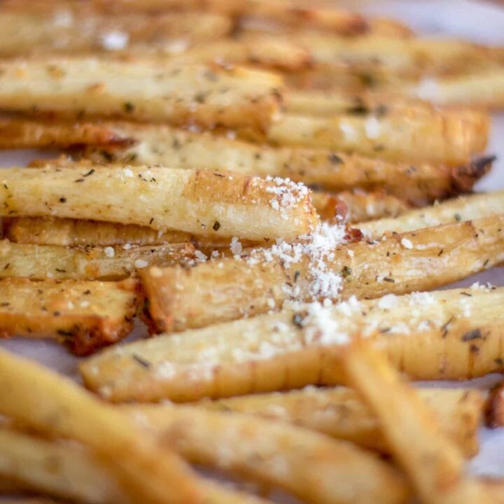 Parmesan rosemary baked parsnip fries on parchment paper